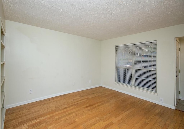 spare room with hardwood / wood-style floors and a textured ceiling