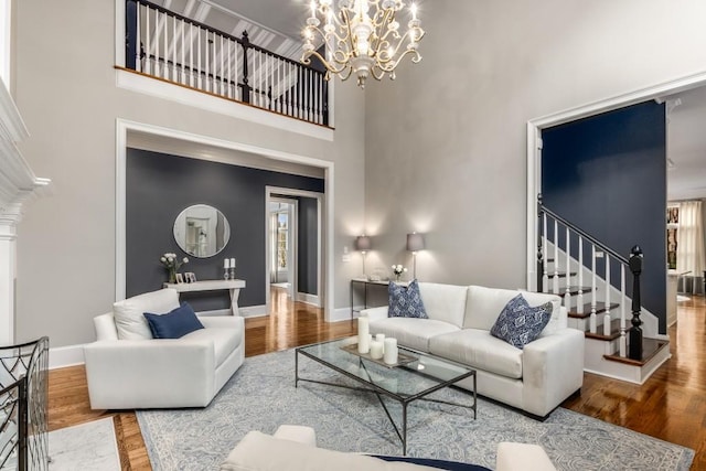 living room featuring a towering ceiling, hardwood / wood-style floors, and a notable chandelier