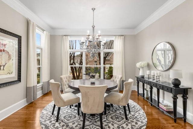 dining area with crown molding, hardwood / wood-style floors, and an inviting chandelier