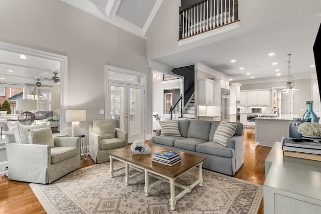 living room featuring french doors, high vaulted ceiling, ceiling fan, and light hardwood / wood-style flooring