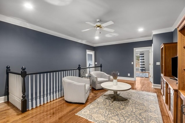 living area featuring crown molding, hardwood / wood-style flooring, and ceiling fan