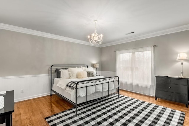 bedroom featuring crown molding, a notable chandelier, and light wood-type flooring