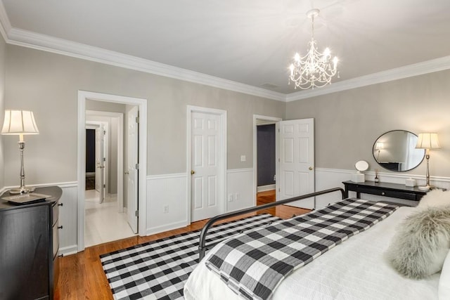 bedroom featuring an inviting chandelier, hardwood / wood-style flooring, and crown molding