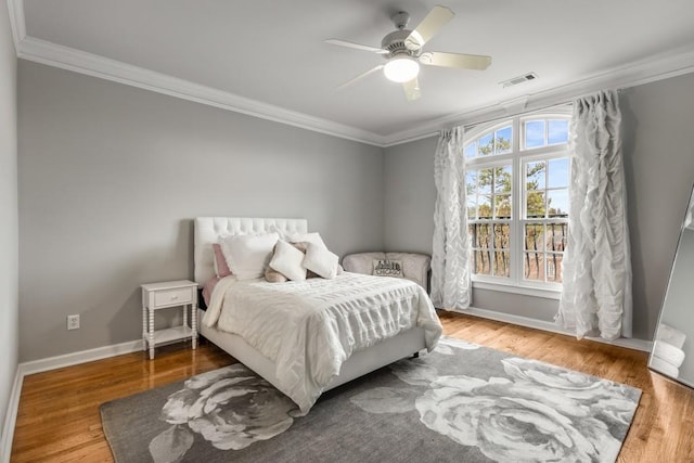 bedroom featuring crown molding, hardwood / wood-style floors, and ceiling fan