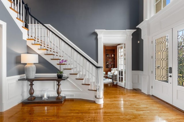 entrance foyer with a towering ceiling and light hardwood / wood-style floors