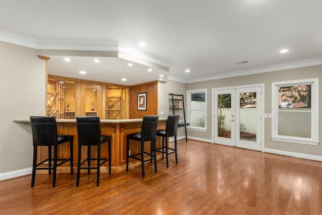 bar with french doors, ornamental molding, and hardwood / wood-style floors