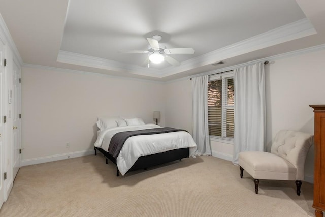 bedroom with ornamental molding, a tray ceiling, and light carpet