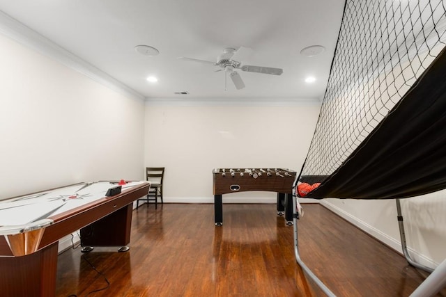 playroom with dark hardwood / wood-style flooring, crown molding, and ceiling fan