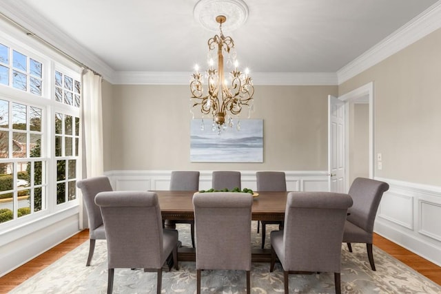 dining room featuring a notable chandelier, plenty of natural light, hardwood / wood-style floors, and ornamental molding