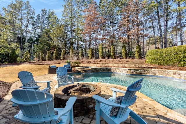 view of swimming pool with a patio area, pool water feature, and an outdoor fire pit