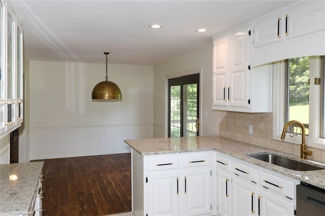 kitchen with dishwasher, sink, white cabinetry, and pendant lighting