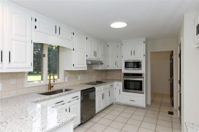 kitchen with light tile patterned floors, black appliances, white cabinets, light stone counters, and sink