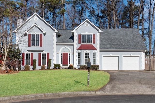 view of front property featuring a garage and a front lawn