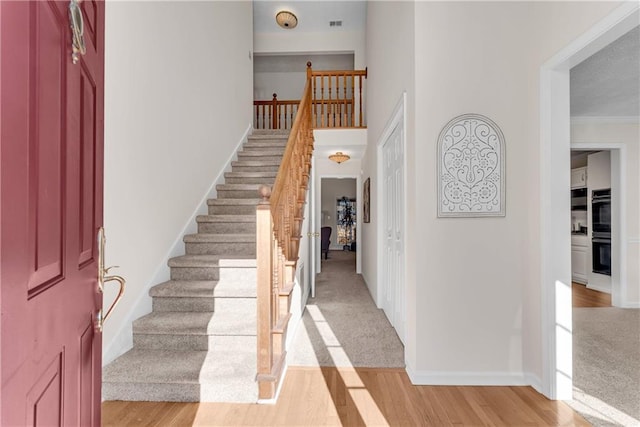 entryway featuring ornamental molding and light hardwood / wood-style flooring