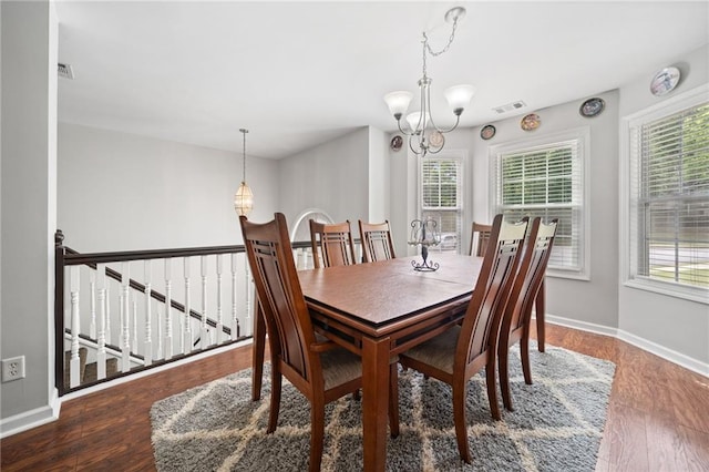 dining room featuring a chandelier, healthy amount of natural light, baseboards, and wood finished floors