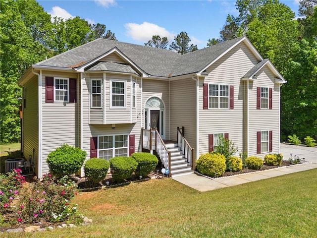 bi-level home featuring a front yard, central AC, and roof with shingles