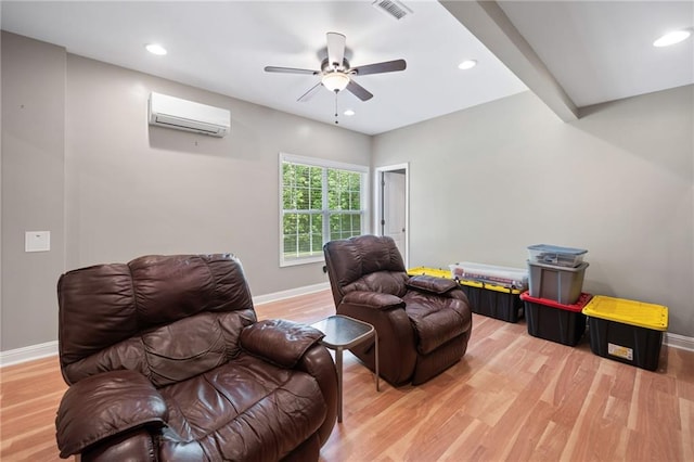 sitting room with a wall unit AC, baseboards, light wood-style floors, a ceiling fan, and recessed lighting