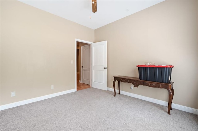 carpeted empty room with baseboards and ceiling fan