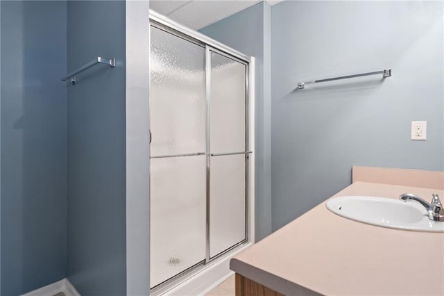 bathroom featuring a sink and a shower stall
