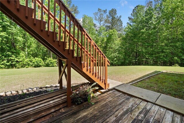 deck with stairway and a lawn