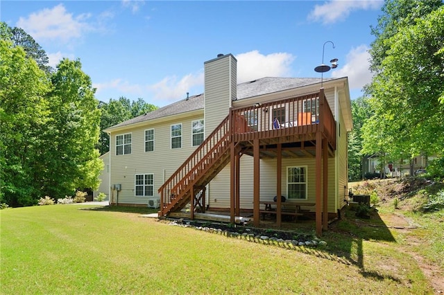 back of property with a yard, a chimney, stairway, and a deck
