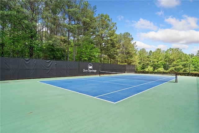 view of tennis court with community basketball court and fence