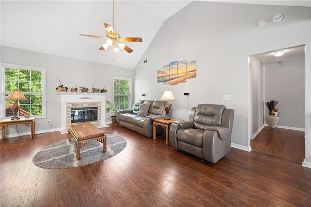 living room featuring ceiling fan, healthy amount of natural light, wood finished floors, a fireplace with flush hearth, and high vaulted ceiling