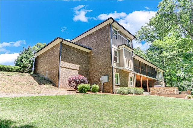 8240 Hurakan Creek Xing, Cumming, GA 30028 - view of side of property with a yard, brick siding, board and batten siding, and a sunroom