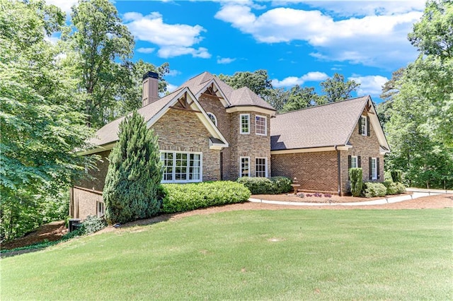 8240 Hurakan Creek Xing, Cumming, GA 30028 - view of front of home featuring a chimney, a front lawn, brick siding, and stone siding