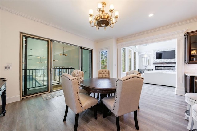 dining space with crown molding, baseboards, wood finished floors, and a notable chandelier