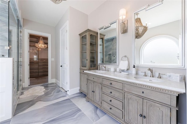 full bathroom featuring marble finish floor, double vanity, a sink, and baseboards