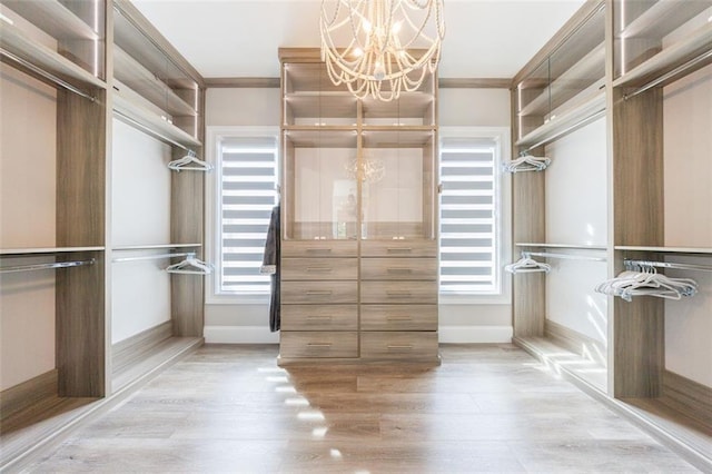 walk in closet with light wood-style floors