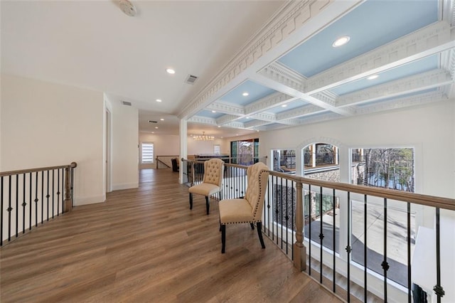 corridor with beamed ceiling, coffered ceiling, wood finished floors, and an upstairs landing