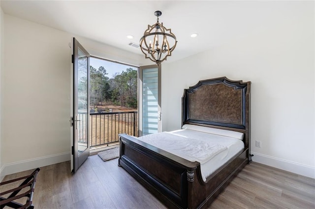 bedroom with access to outside, wood finished floors, and baseboards