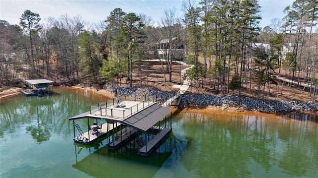 dock area with a water view, boat lift, and stairs