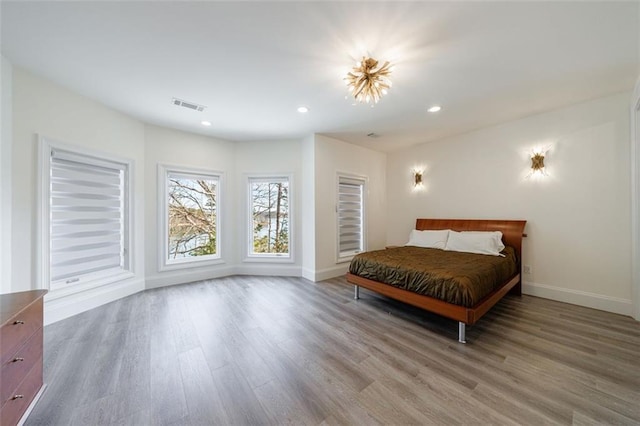 bedroom with recessed lighting, wood finished floors, visible vents, and baseboards