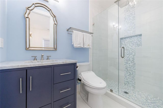 bathroom with a stall shower, vanity, and toilet