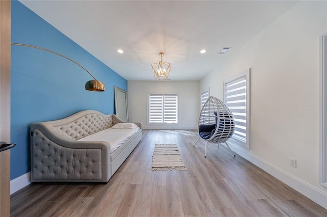 living area with a chandelier, recessed lighting, wood finished floors, and baseboards