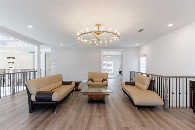 living area with recessed lighting, wood finished floors, visible vents, and an inviting chandelier