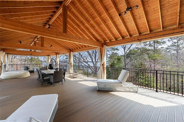 wooden terrace with outdoor dining space and a gazebo