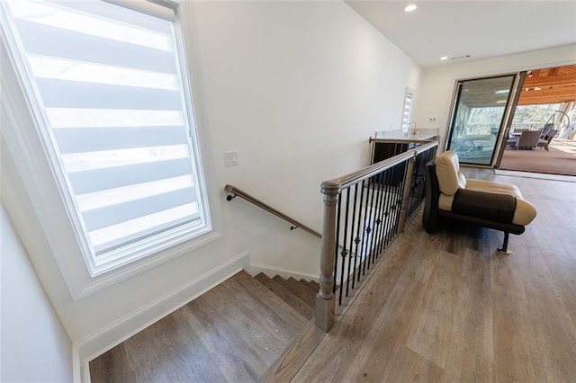 stairway featuring baseboards, wood finished floors, and recessed lighting