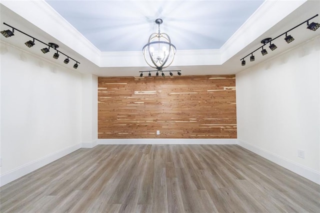 mudroom with wood walls, a raised ceiling, wood finished floors, and an inviting chandelier