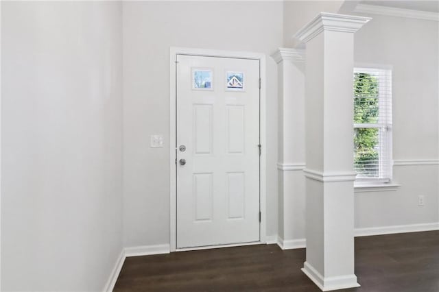 entrance foyer featuring ornate columns, a healthy amount of sunlight, dark hardwood / wood-style floors, and ornamental molding