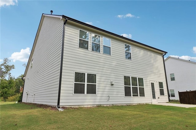 rear view of property featuring a lawn