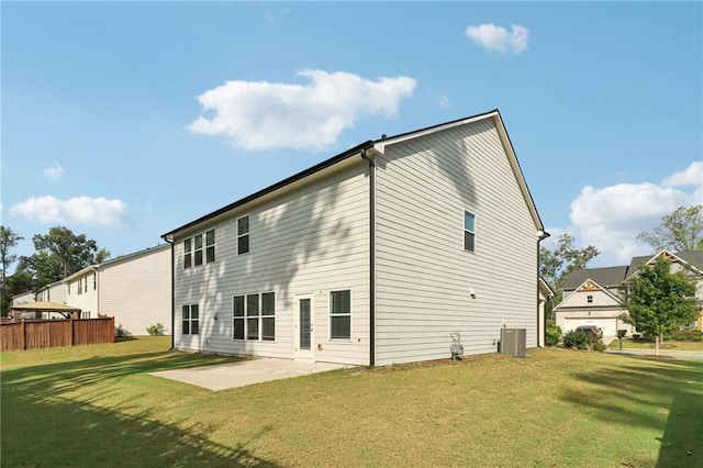 rear view of house with cooling unit, a patio area, and a yard