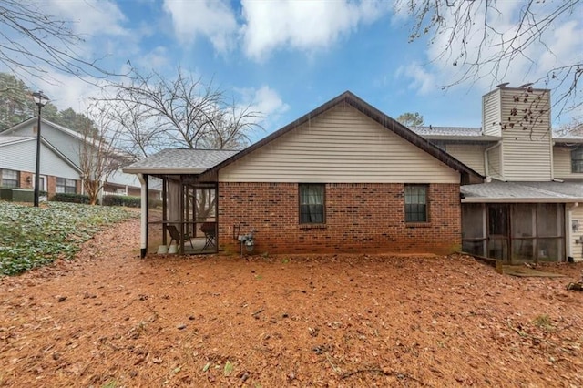 back of property with a sunroom