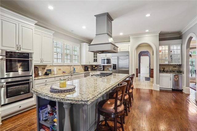 kitchen featuring appliances with stainless steel finishes, white cabinetry, a kitchen island, and plenty of natural light