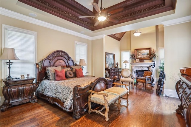 bedroom featuring ornamental molding, ceiling fan, a raised ceiling, and hardwood / wood-style flooring