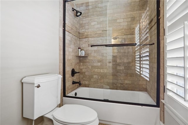 bathroom with enclosed tub / shower combo and toilet