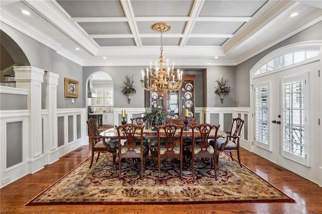 dining area featuring coffered ceiling, ornamental molding, dark wood-type flooring, and french doors